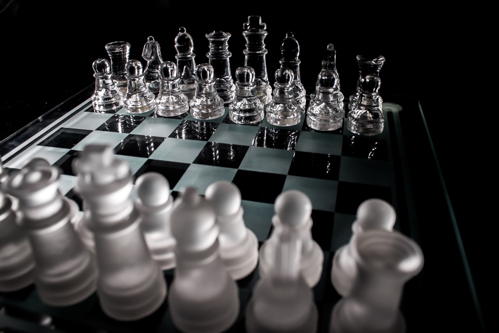 Tabuleiro de jogo de xadrez com peças brancas e transparentes