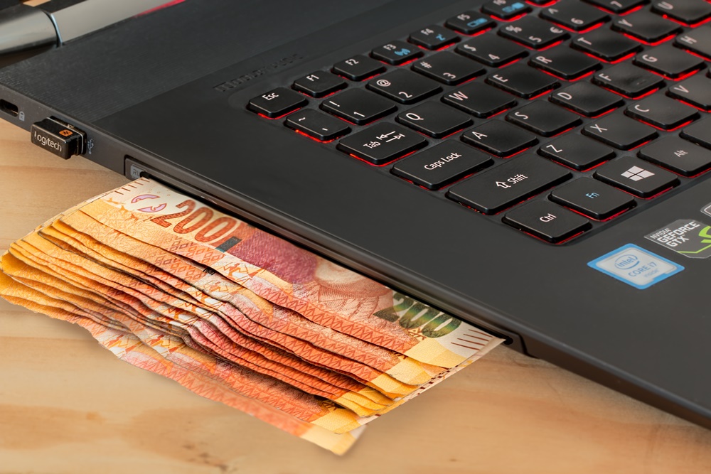 notas de dinheiro embaixo de um notebook